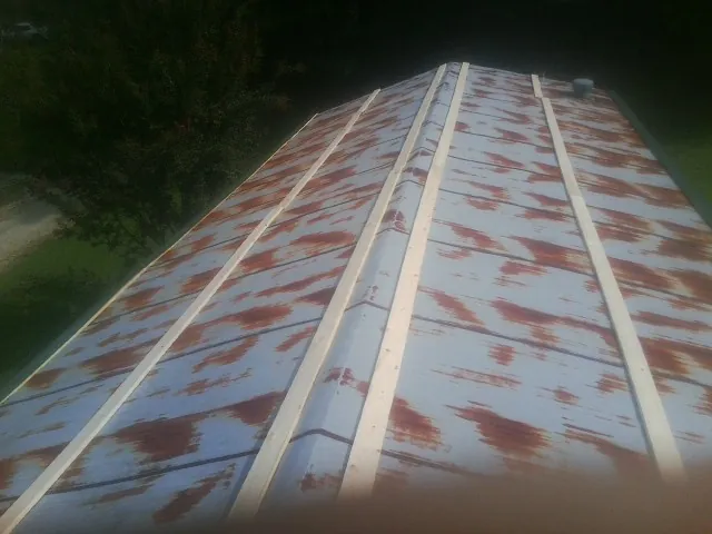 Rusted metal roof panels with new wood purlins before replacement — Storm Damage Roof Repair in Irving by Roofing Brothers