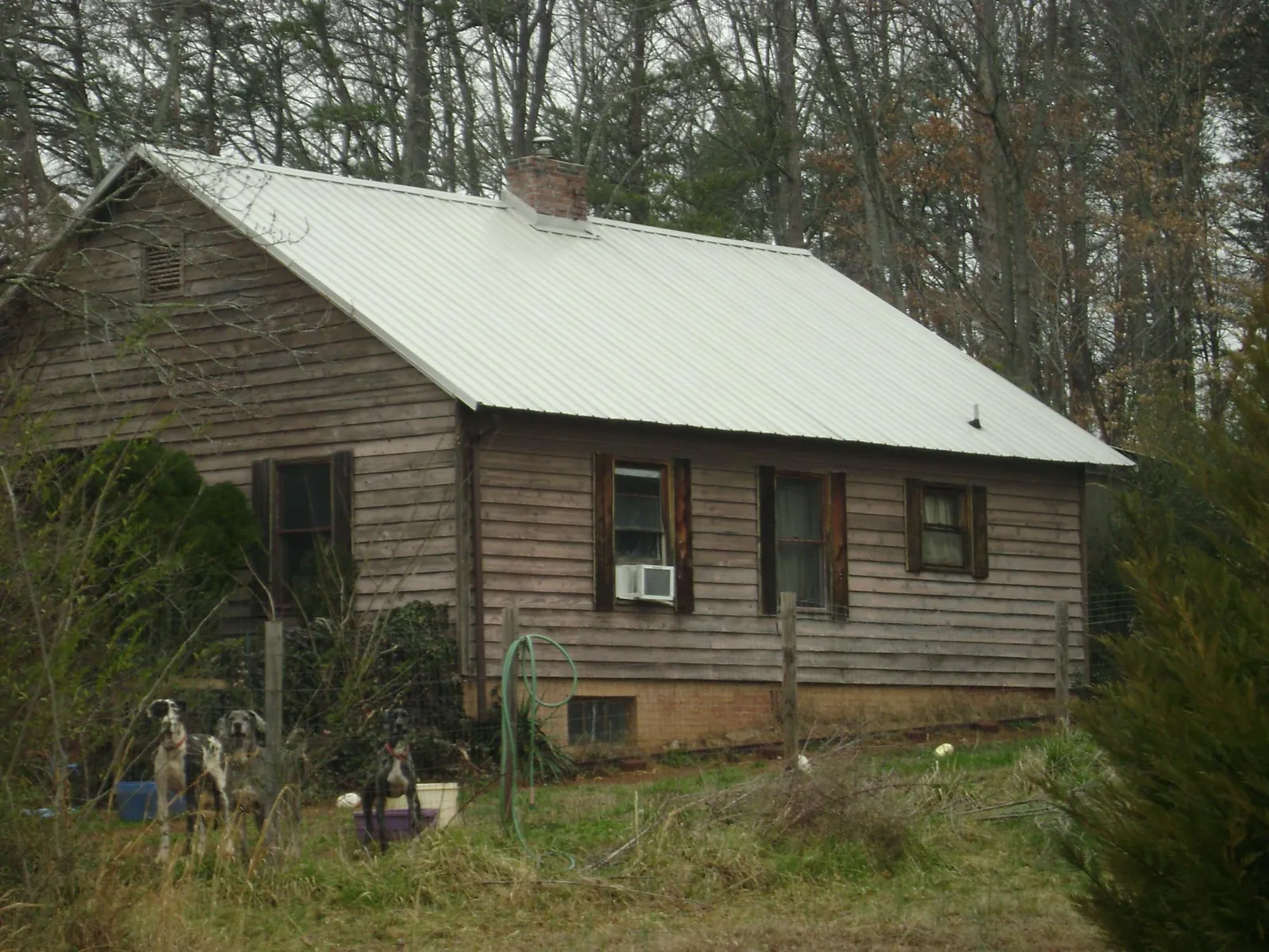 White metal roof on an old wood sided farmhouse, from a Metal Roof Installation job in Irving